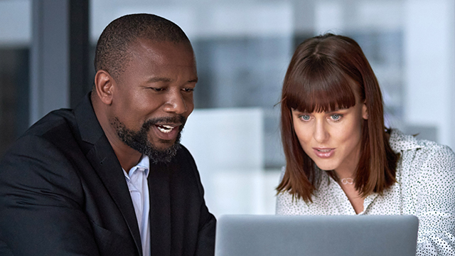 Two colleagues looking at laptop together