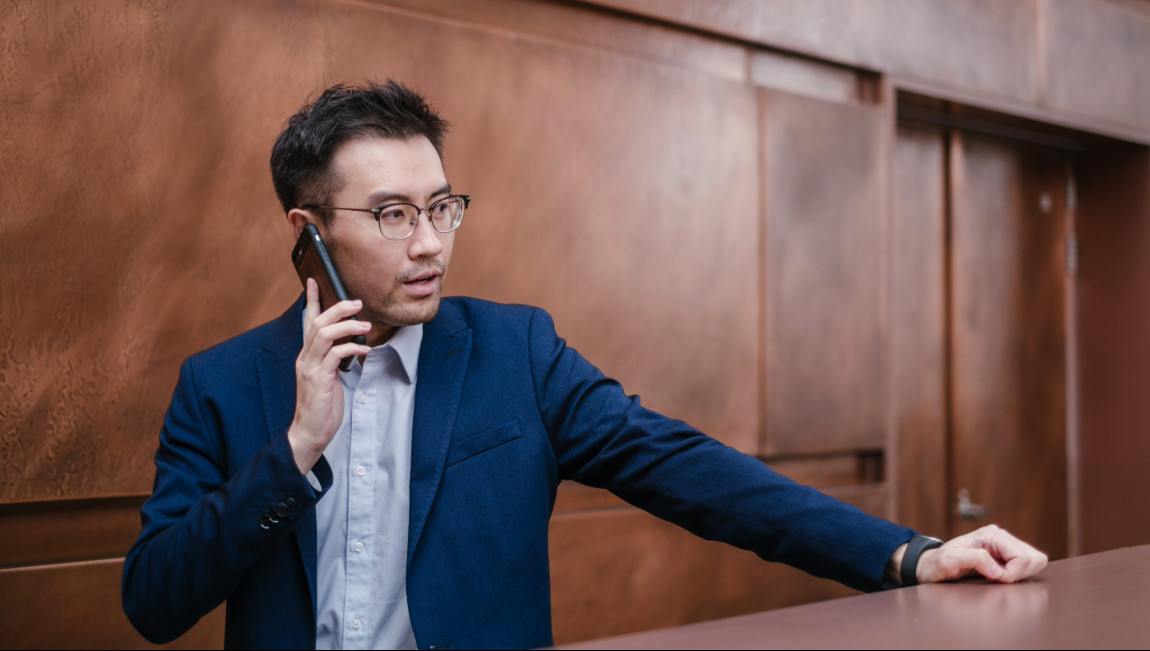 Businessman talking on mobile while leaning against railing