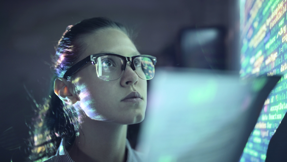 Woman with glasses looking at multiple screens