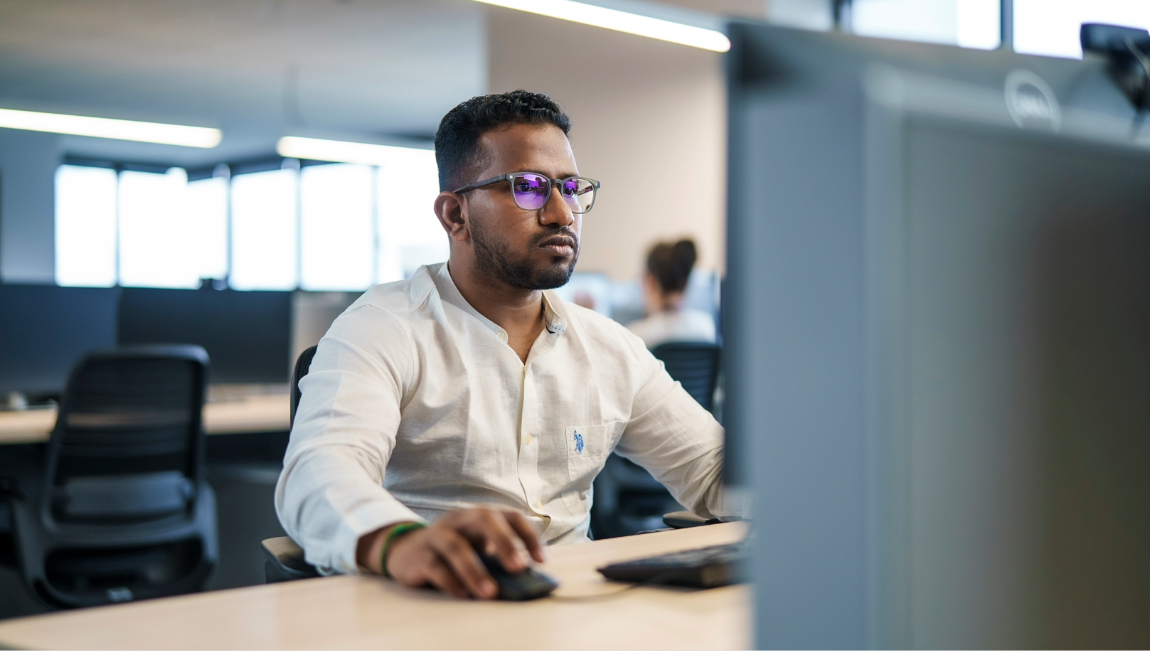 Man with glasses working at desktop computer