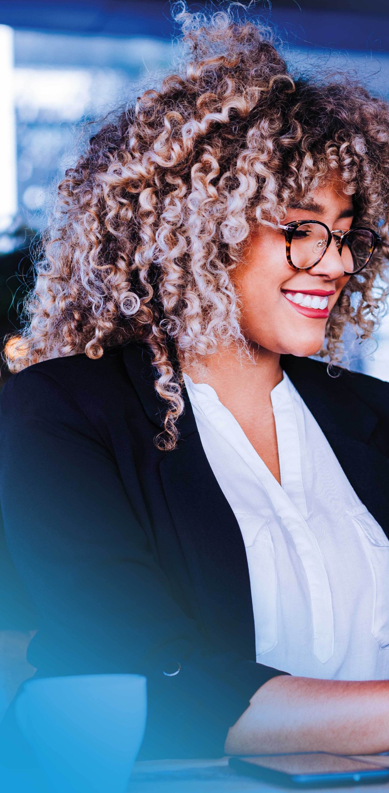 Businesswoman smiling while typing on laptop
